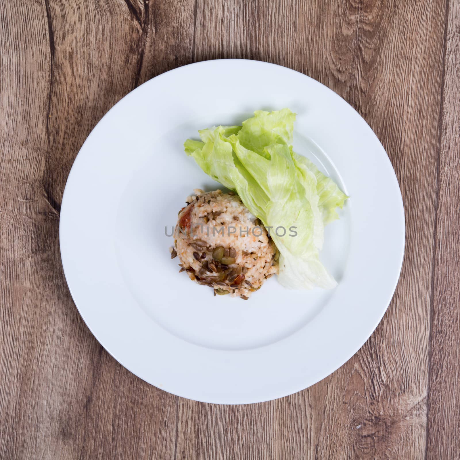 Vegetarian food on a white plate with wooden background