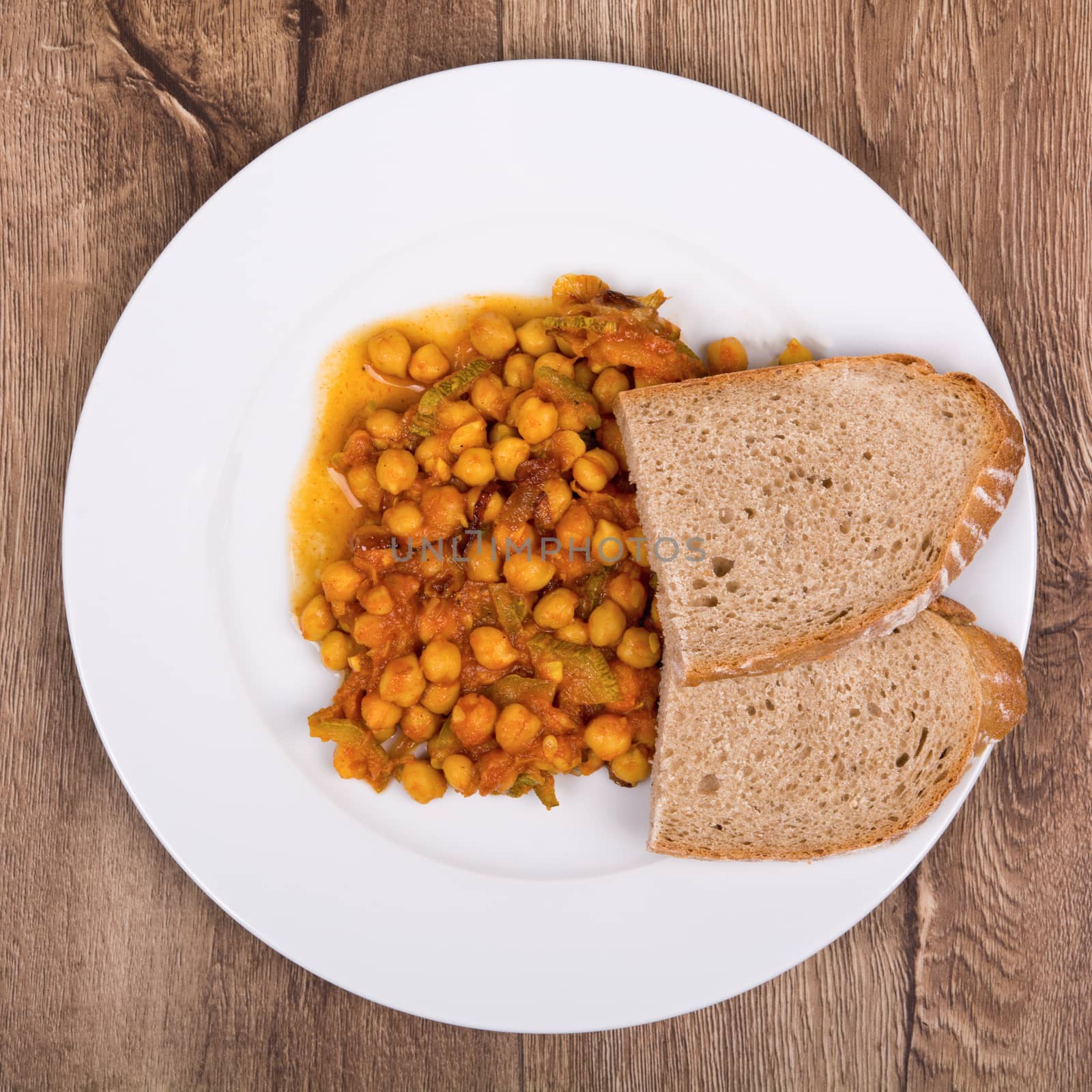 Vegetarian food on a white plate with wooden background