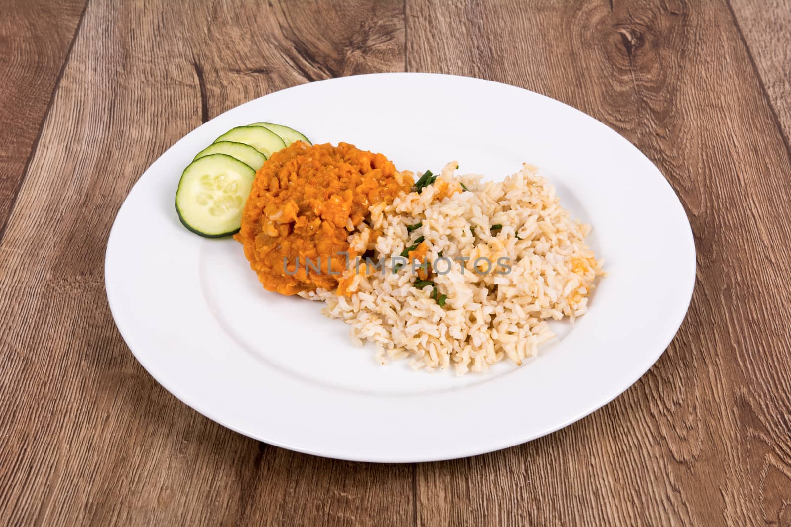 Vegetarian food on a white plate with wooden background