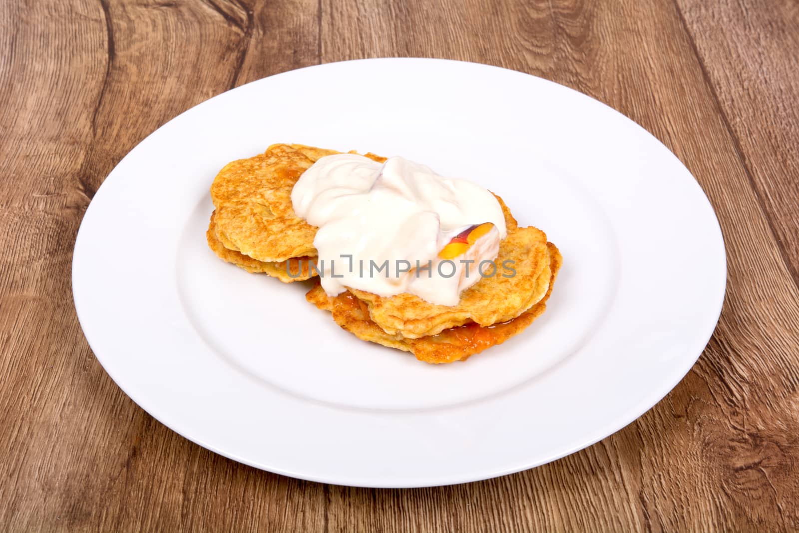 Vegetarian food on a white plate with wooden background