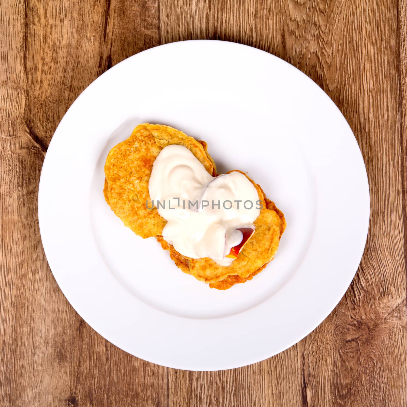 Vegetarian food on a white plate with wooden background