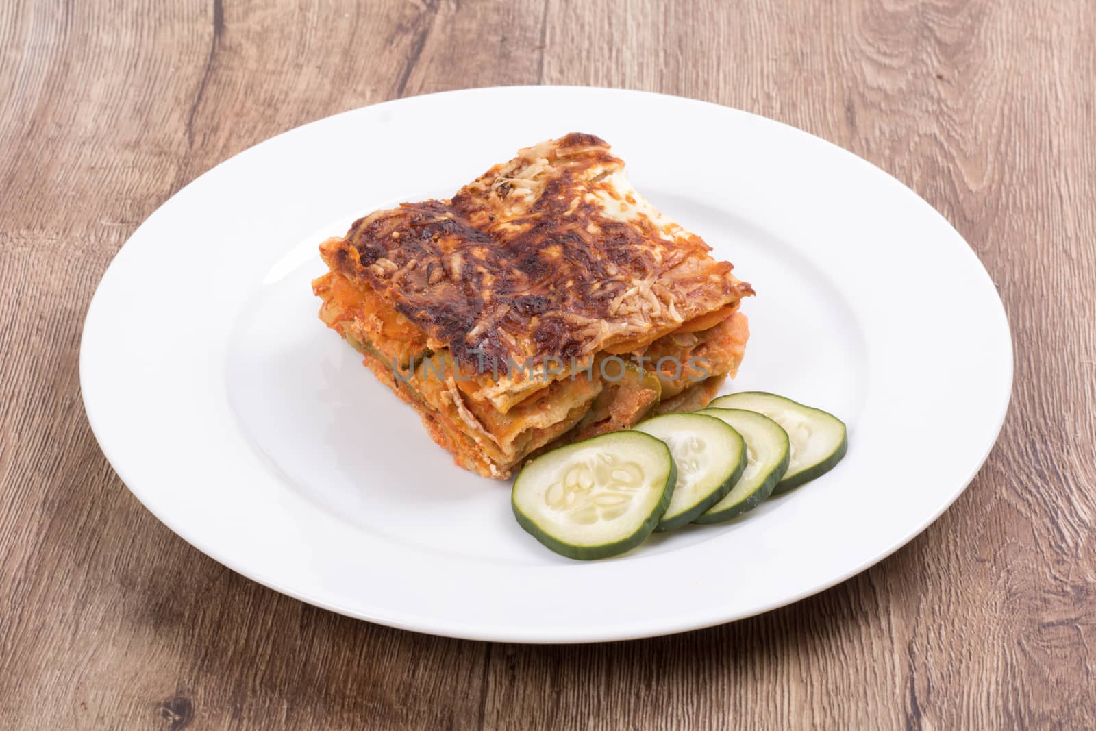Vegetarian food on a white plate with wooden background