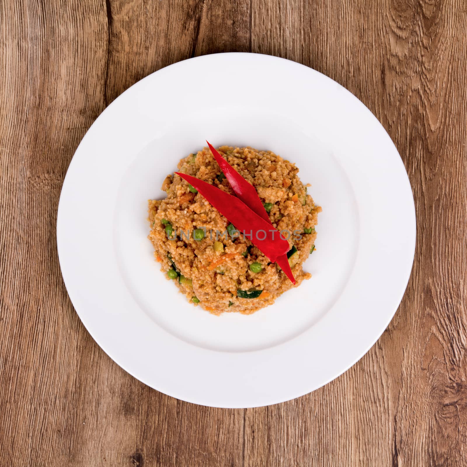 Vegetarian food on a white plate with wooden background