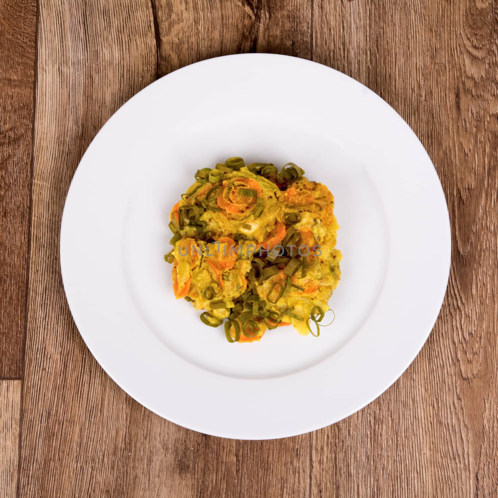 Vegetarian food on a white plate with wooden background