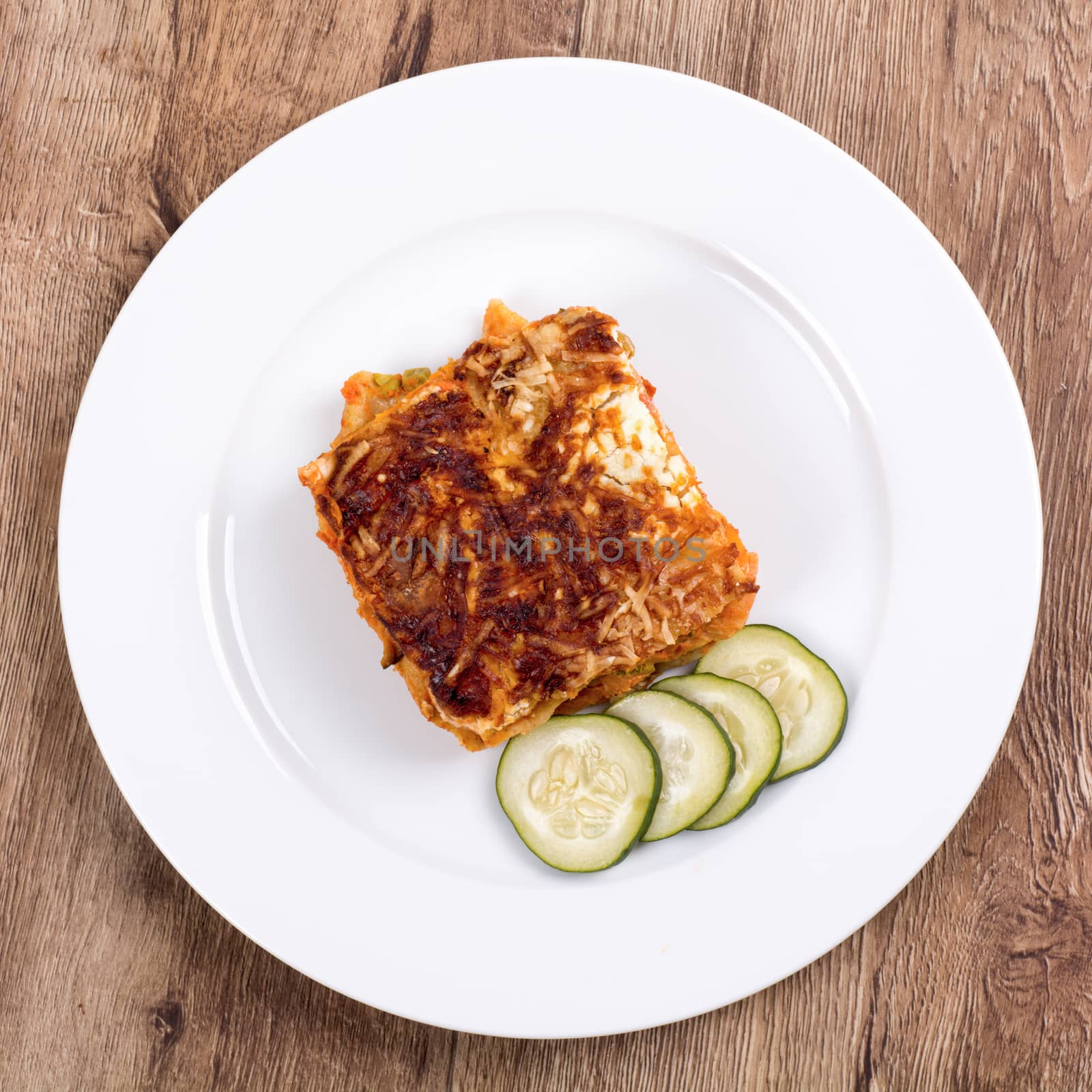 Vegetarian food on a white plate with wooden background