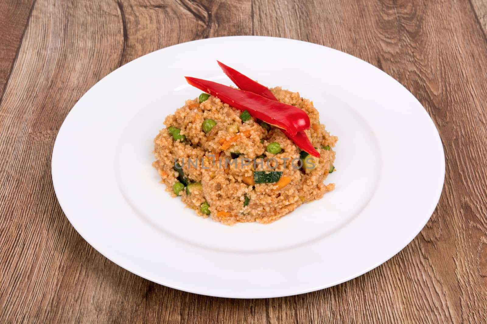 Vegetarian food on a white plate with wooden background