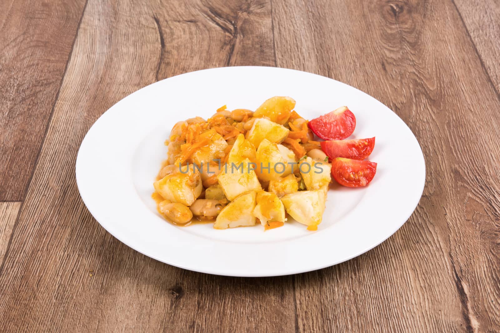 Vegetarian food on a white plate with wooden background