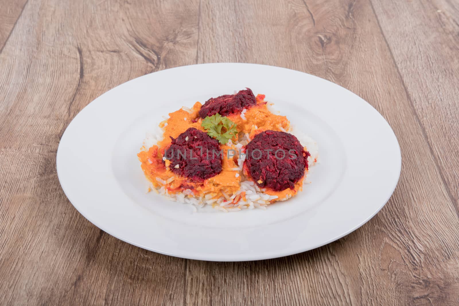 Vegetarian food on a white plate with wooden background