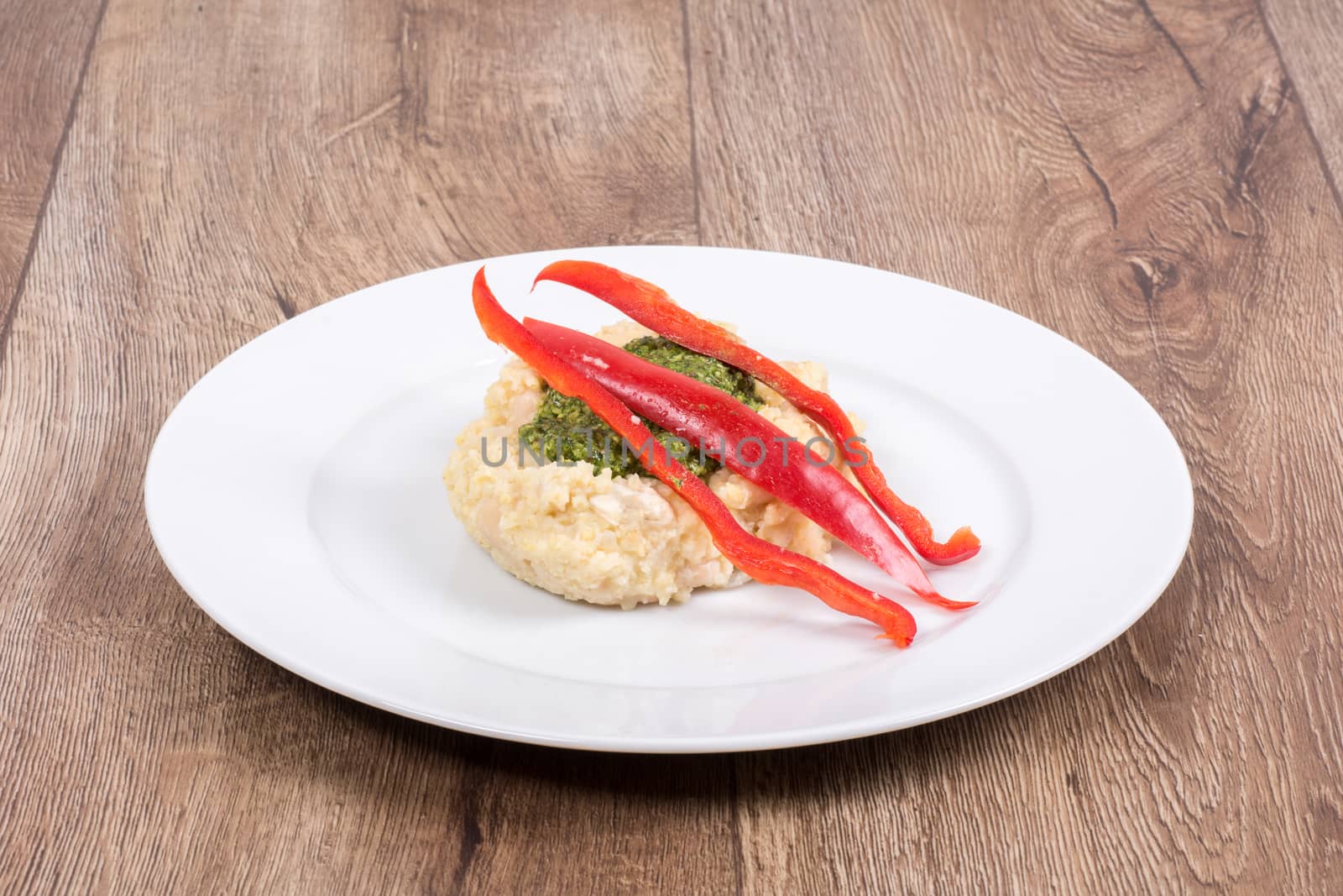 Vegetarian food on a white plate with wooden background