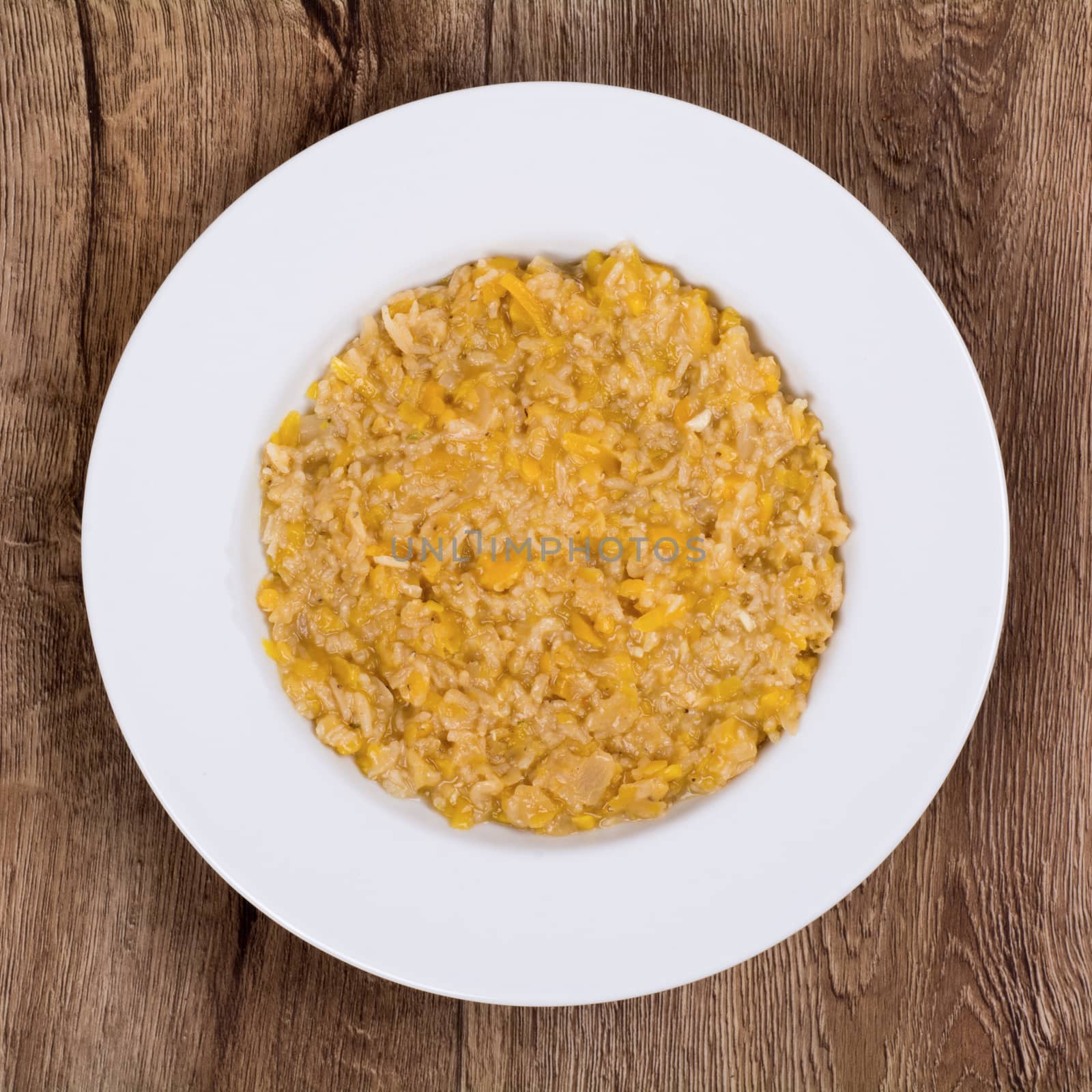 Vegetarian food on a white plate with wooden background