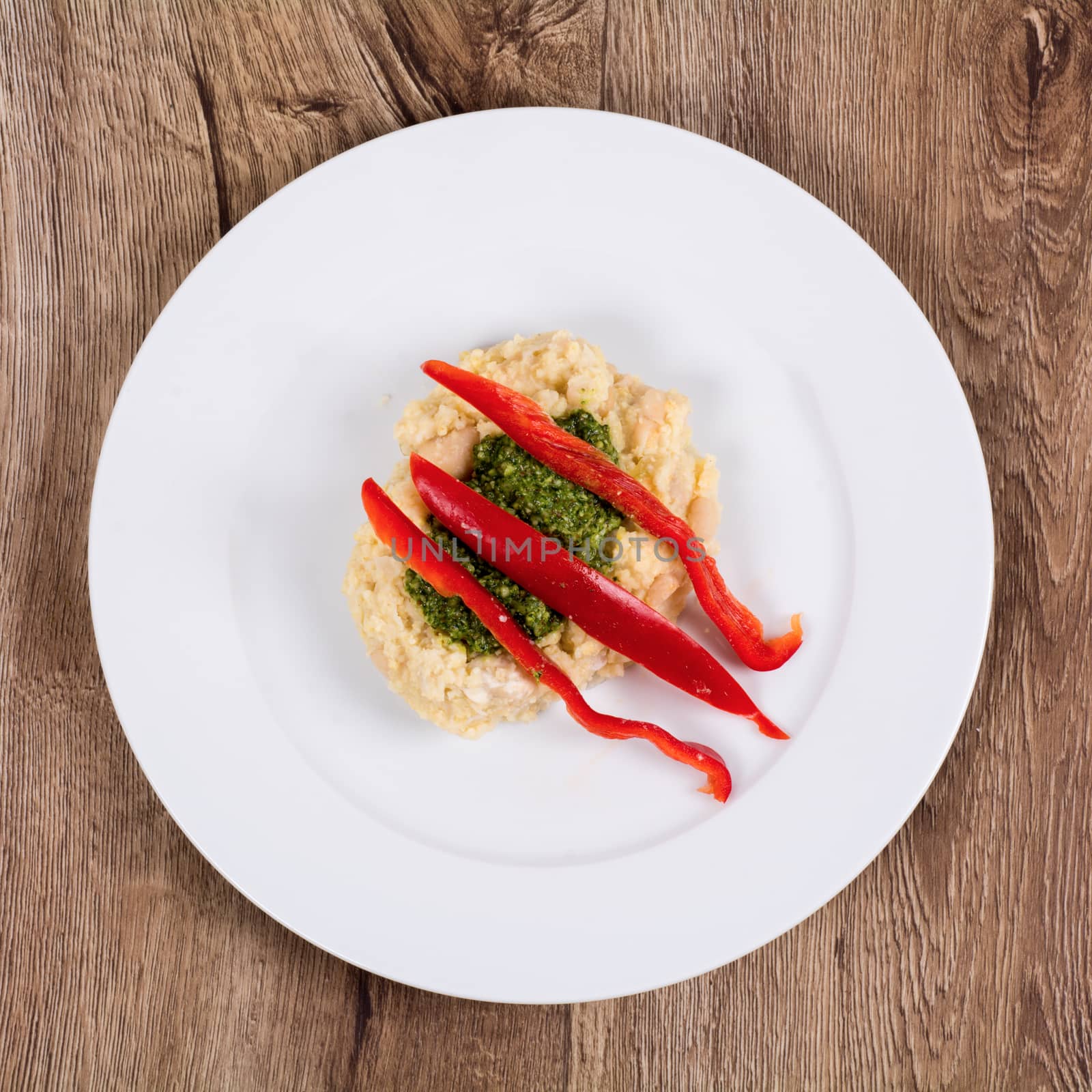 Vegetarian food on a white plate with wooden background