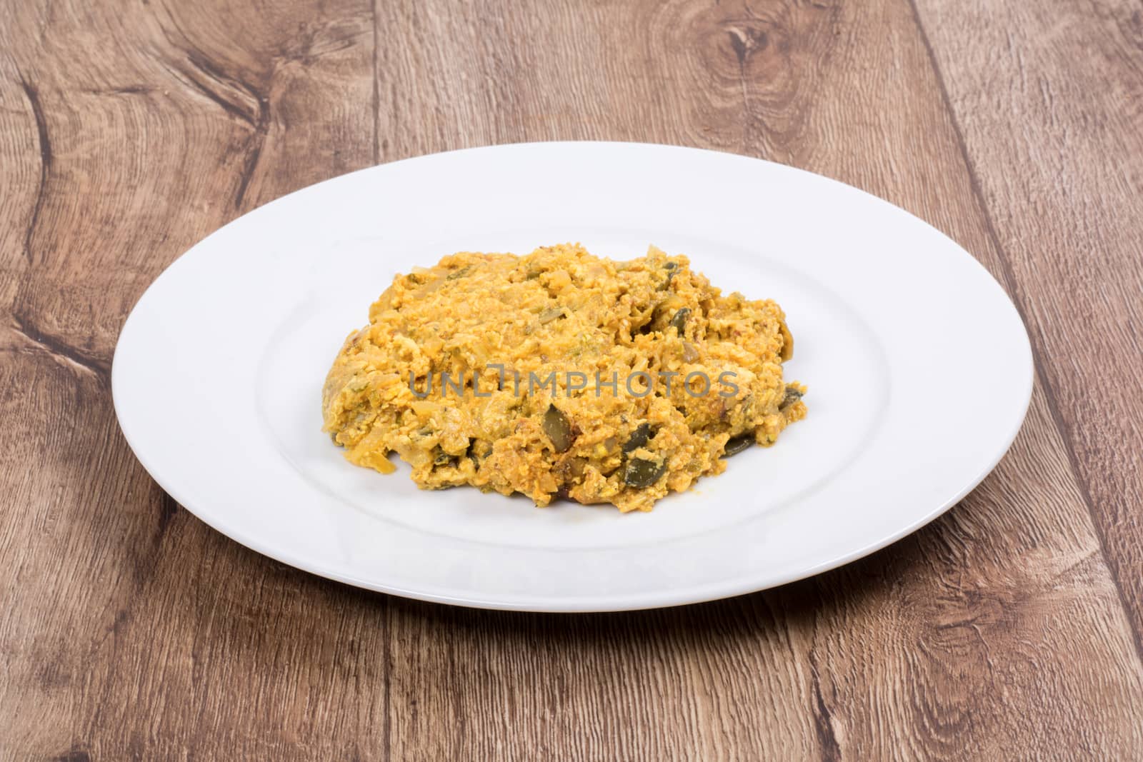 Vegetarian food on a white plate with wooden background