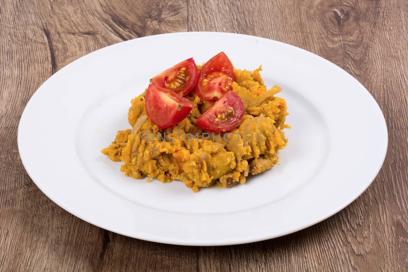 Vegetarian food on a white plate with wooden background
