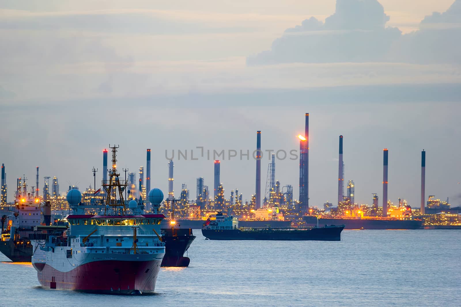 Seismic survey vessel and cargo container ships off the coast of Singapore Island Petroleum Chemical Refinery Plants