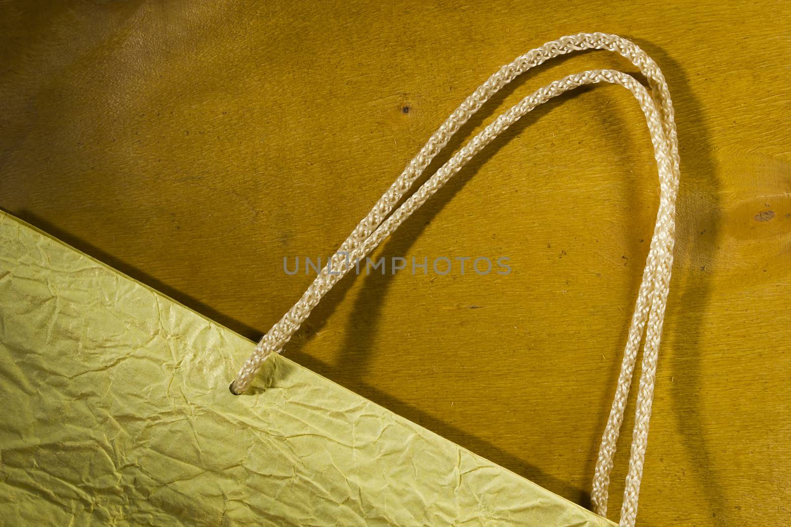 Rope handles from a paper bag on a wooden background