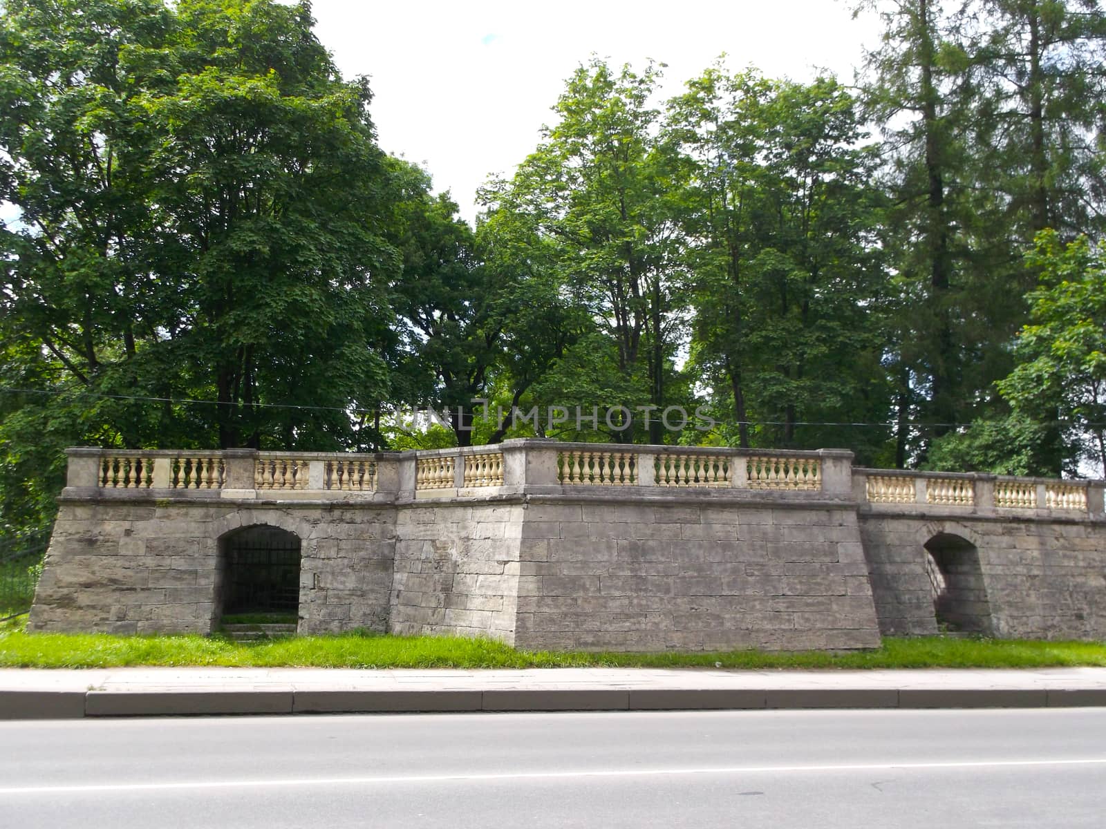 stone construction with railings on the background of green trees