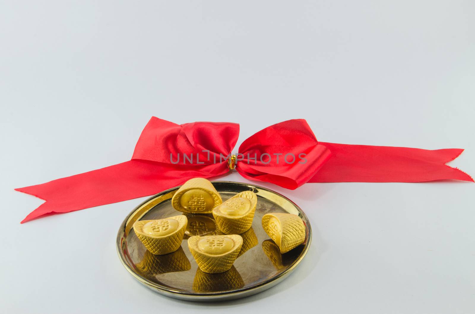 Gold ingot on golden plates white background