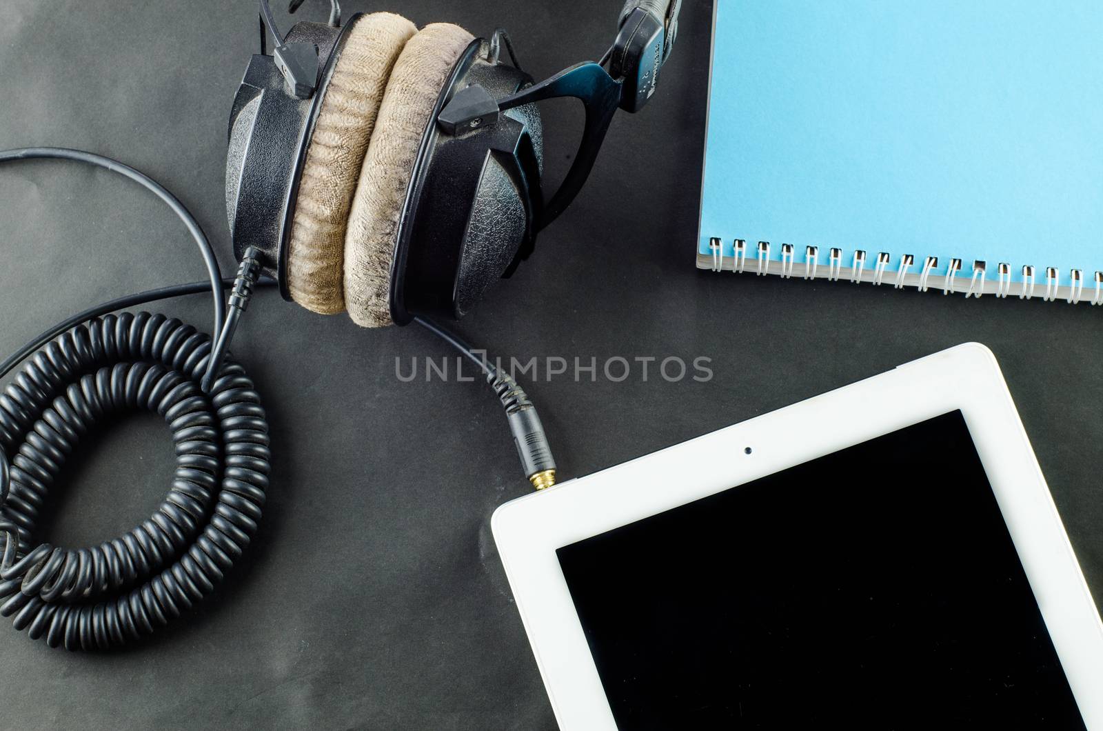 blank notebook in top view with music concept 
Black background headphones