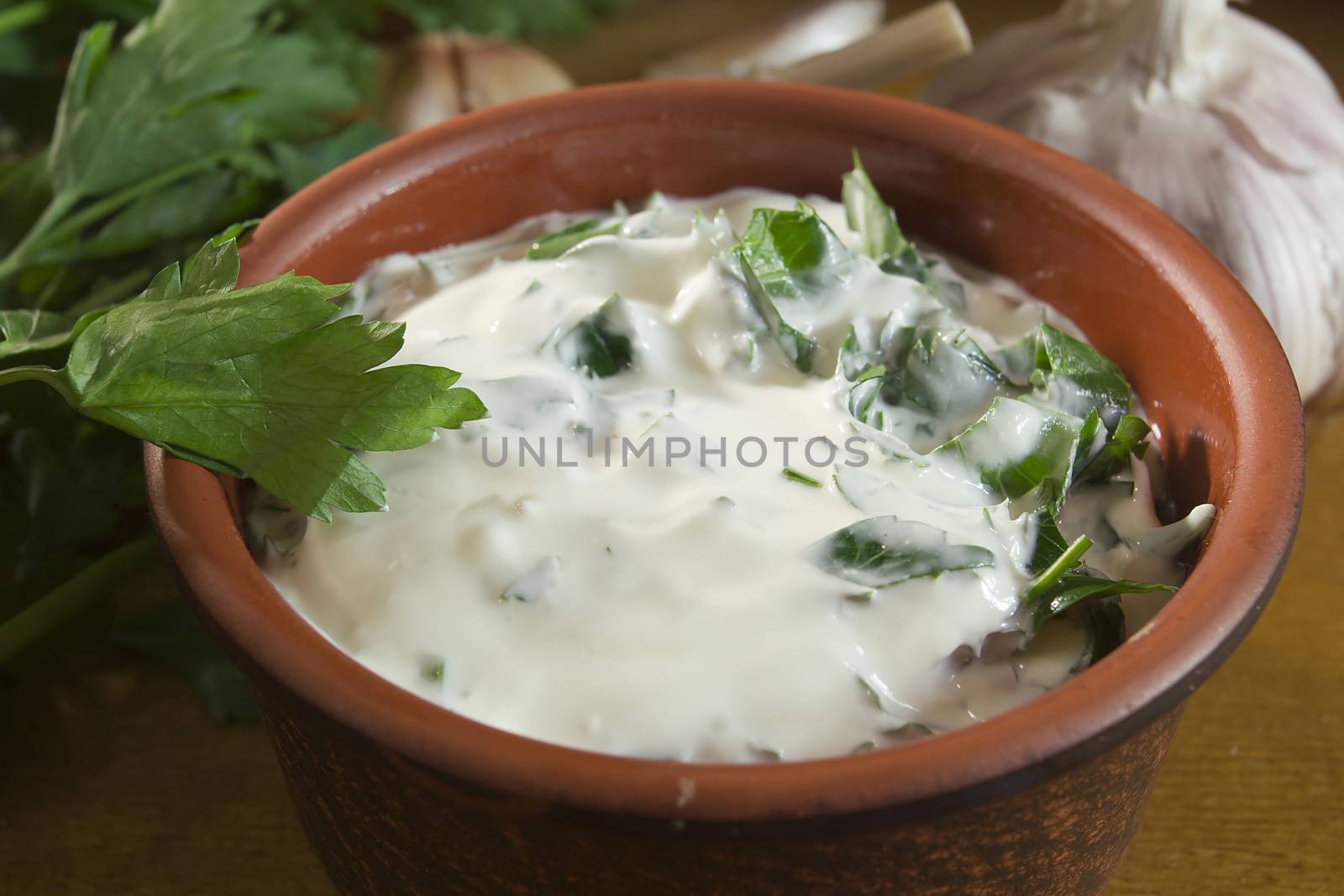 Garlic dip sauce with fresh green parsley leaves