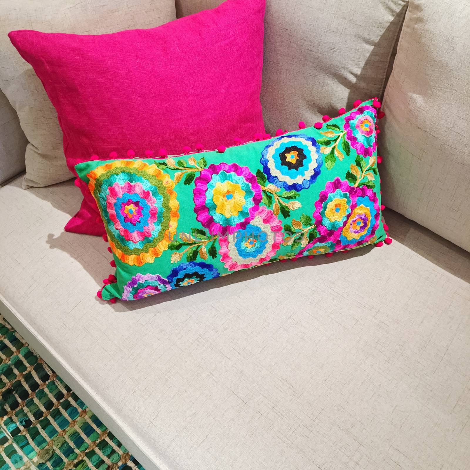 Bright cushions with floral design on a sofa by anikasalsera