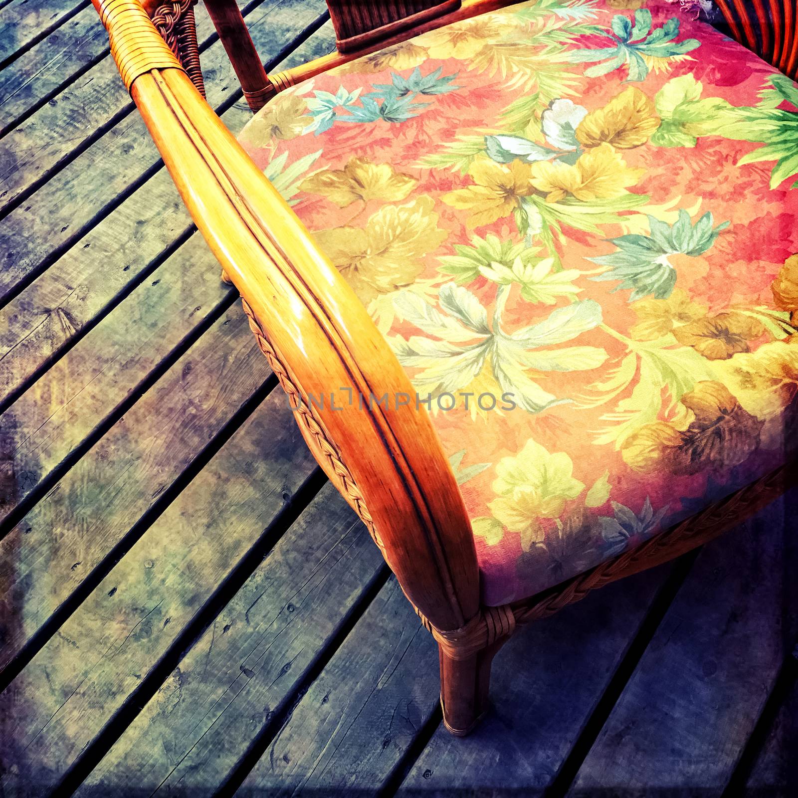 Vintage armchair with floral design, on a dark wooden floor.