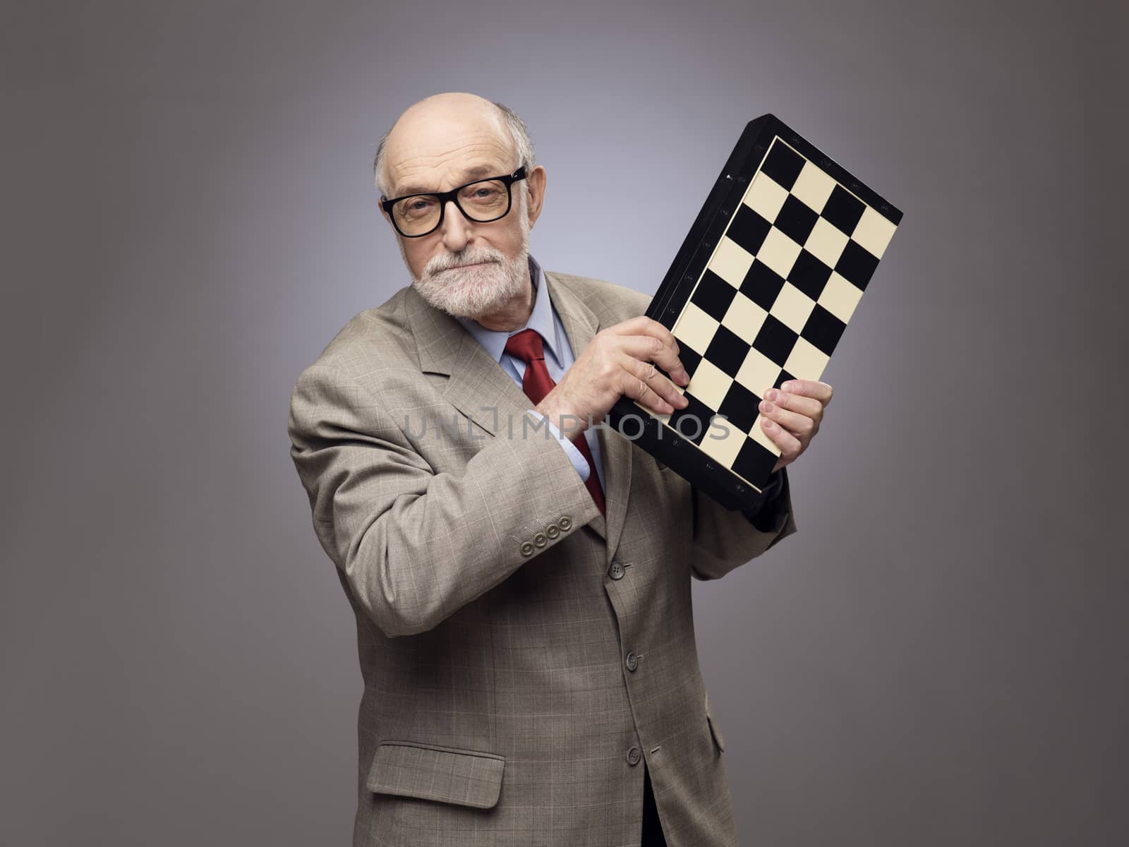 Senior man fighting with chessboard by ALotOfPeople