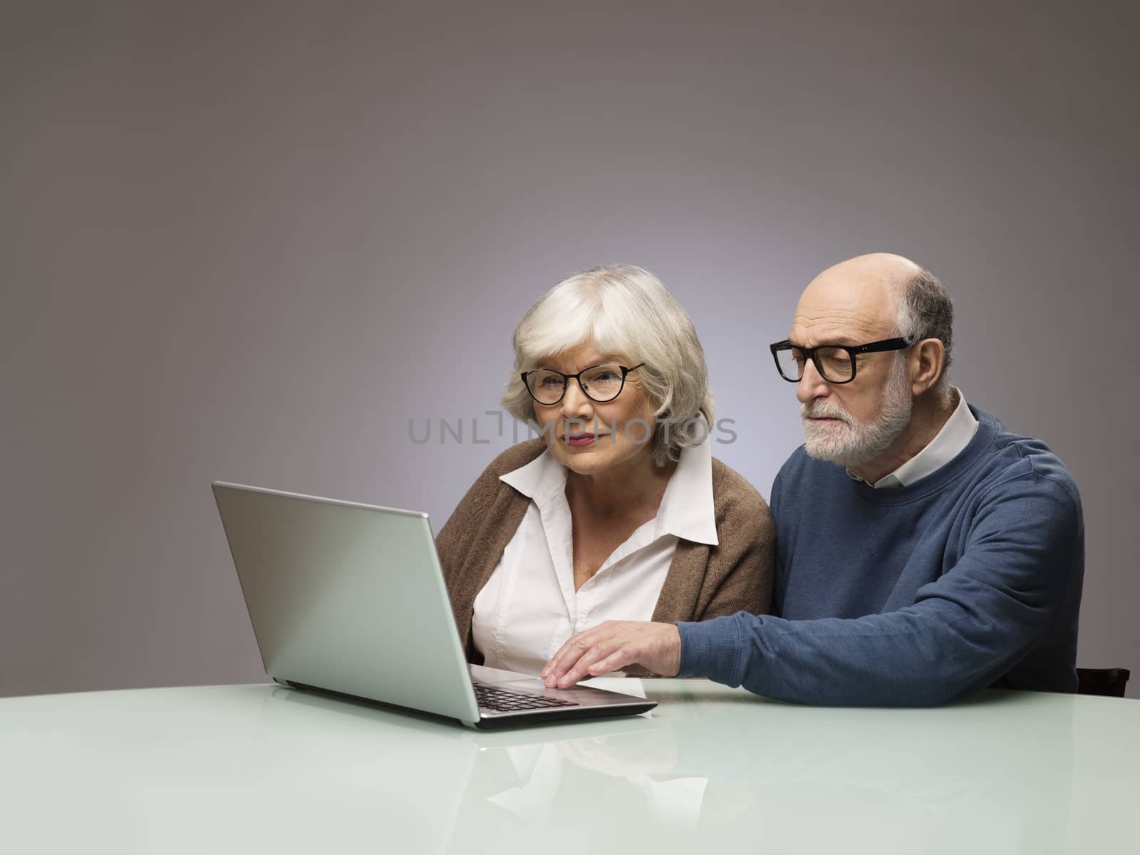 Senior couple looking at laptop by ALotOfPeople