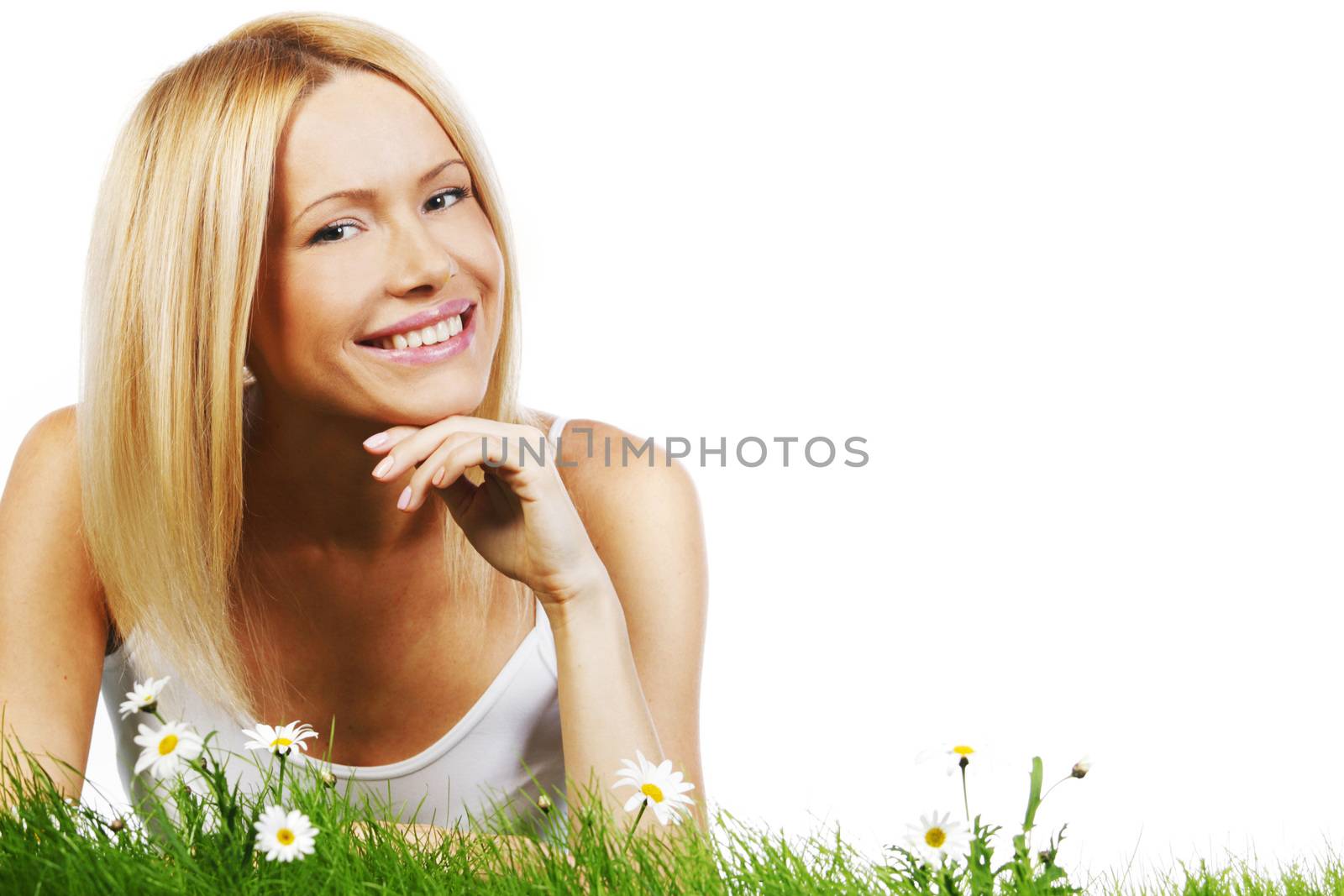 Beautiful young blonde woman lying on grass with chamomile flowers, isolated on white background