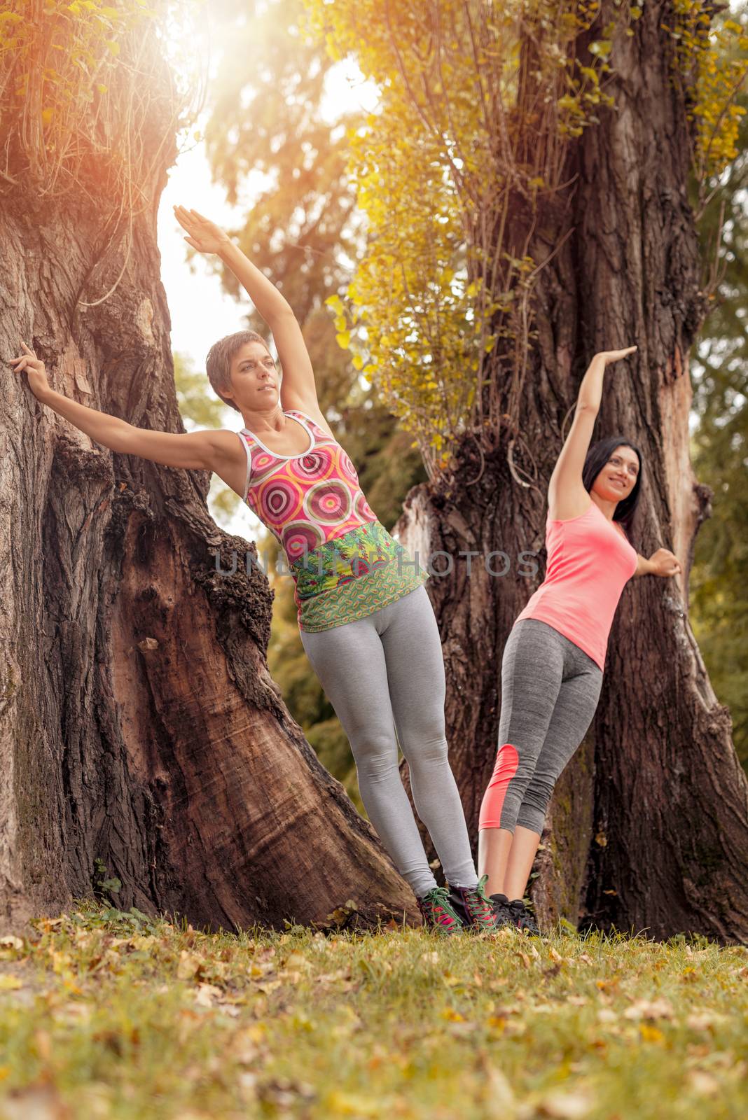 Two beautiful women exercising in the park. 