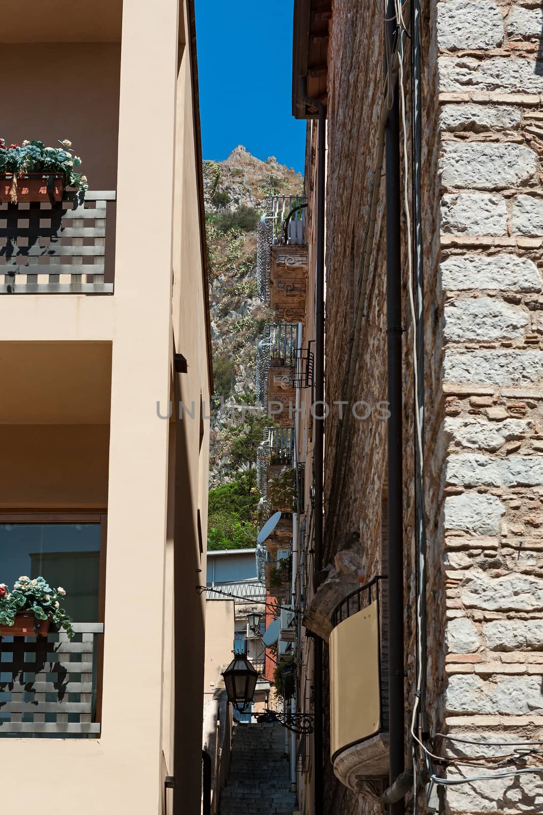 Alley in Taormina with the mountain on background, Sicily, Italy