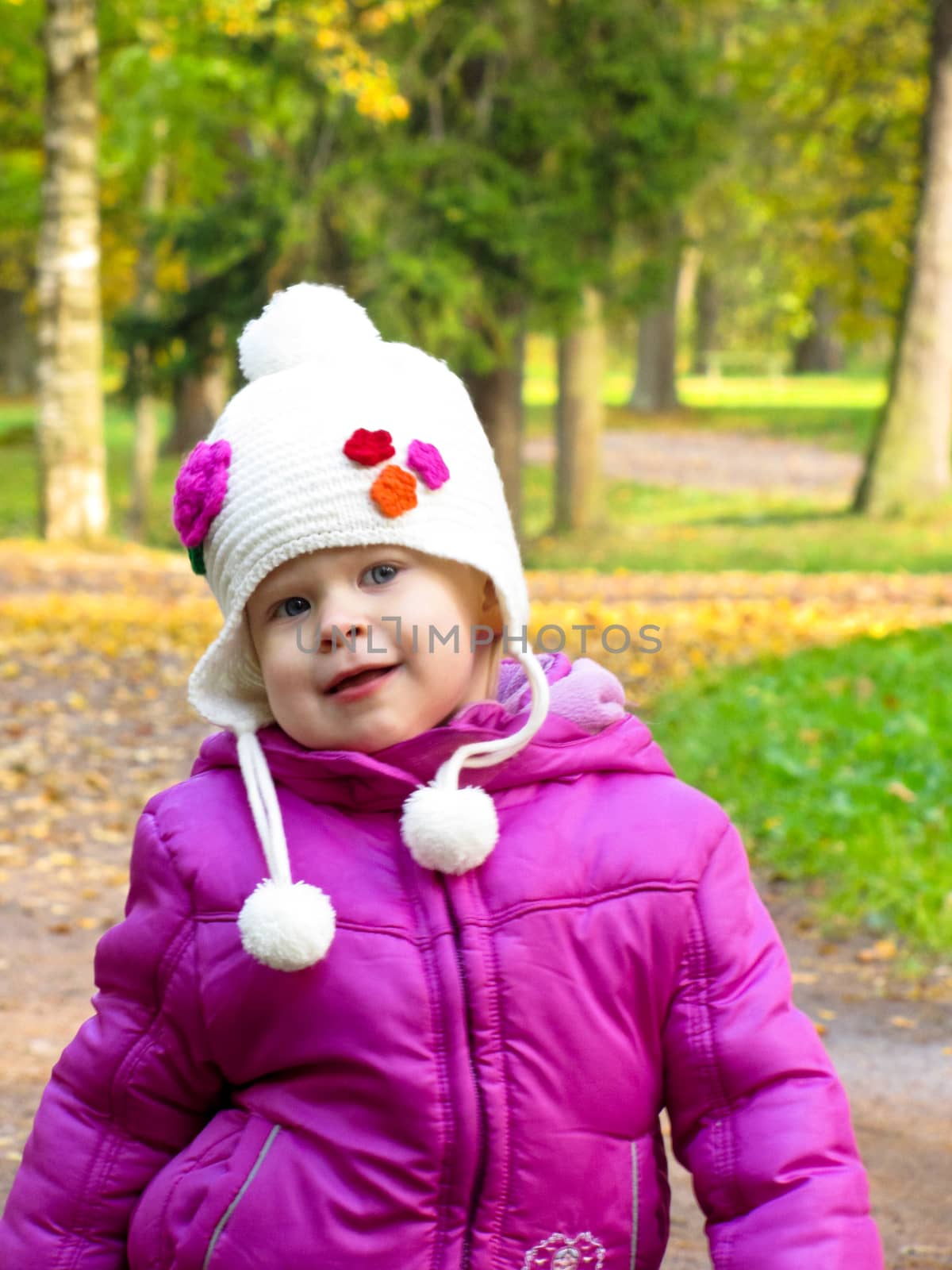 smiling girl in a white hat on a background of green meadows