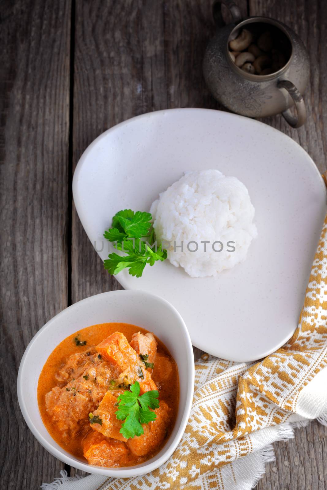 Chicken curry and rice served on a wooden surface