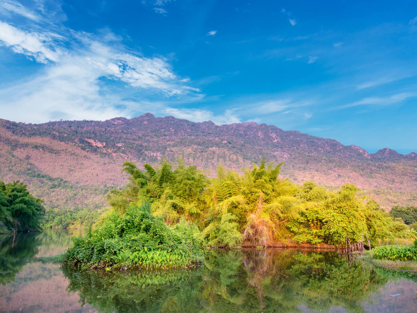 Tree in river with mountain and blue sky in morning,Thailand