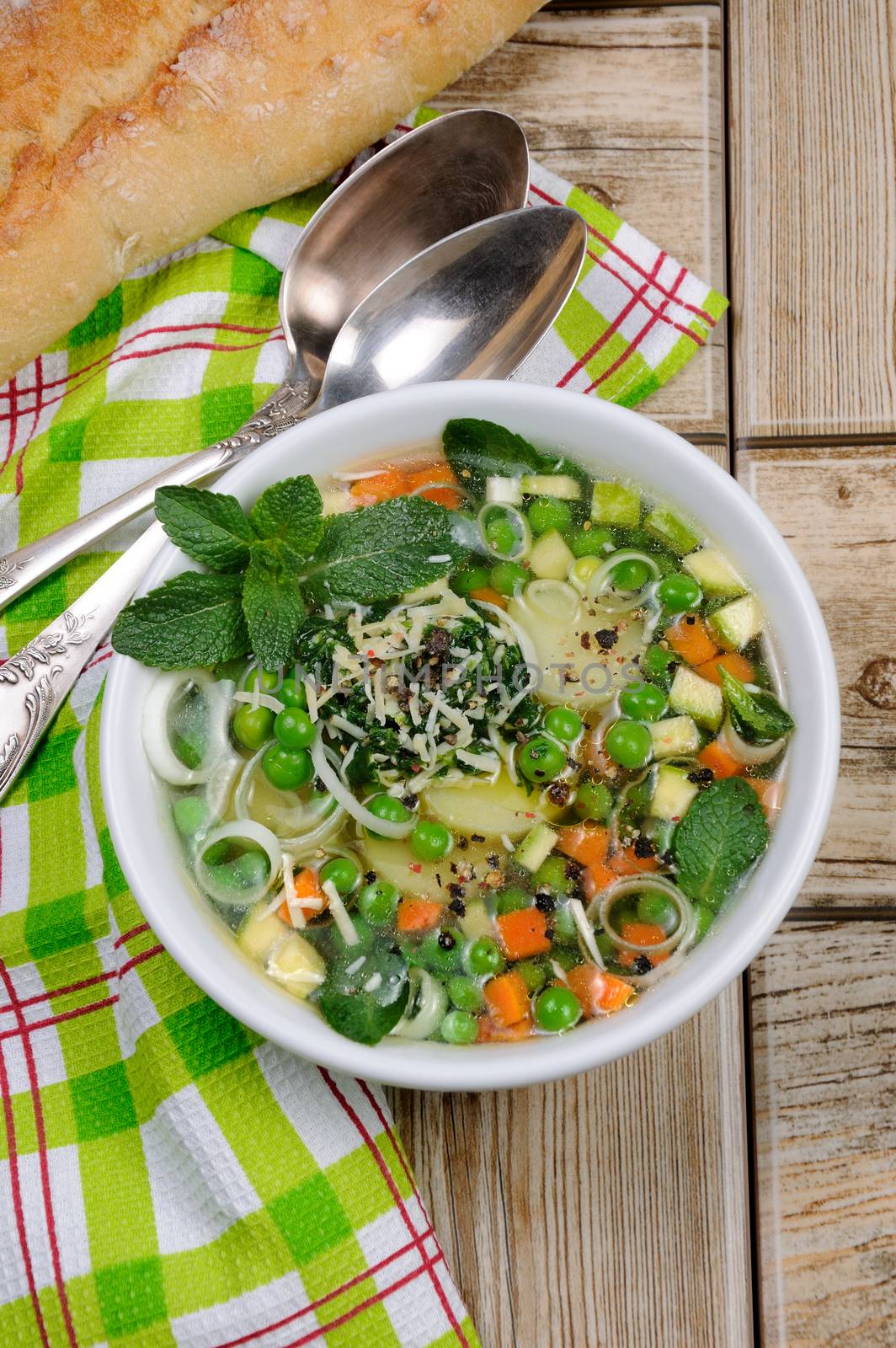 Light, refreshing soup of carrots, zucchini, potatoes, leeks, peas, pesto, parmesan and mint leaves.
View from above.
