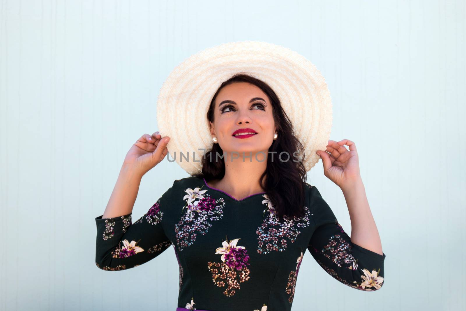 Vintage girl with beautiful floral dress with a white hat.