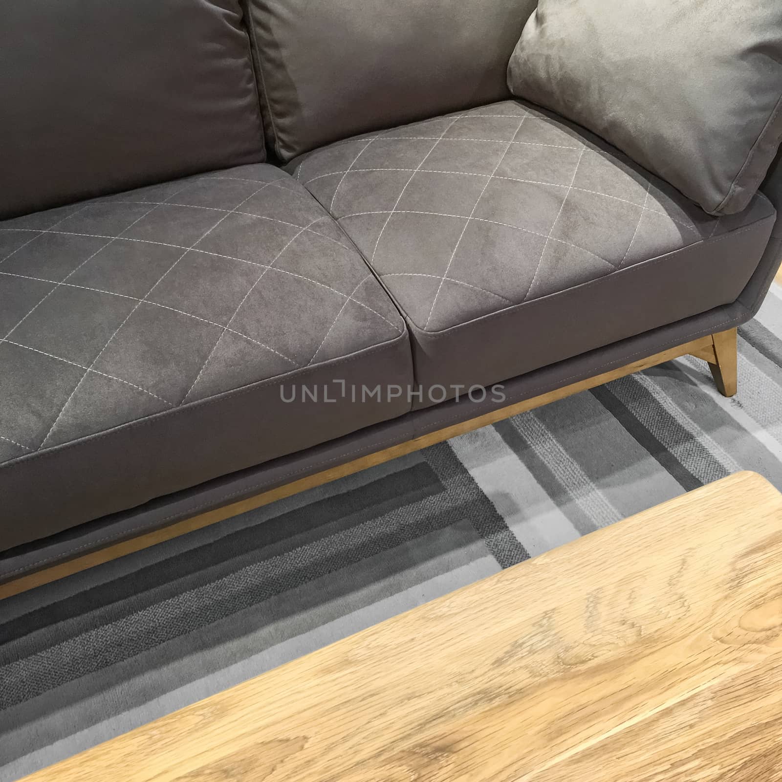Comfortable gray sofa and wooden coffee table. Modern style furniture.