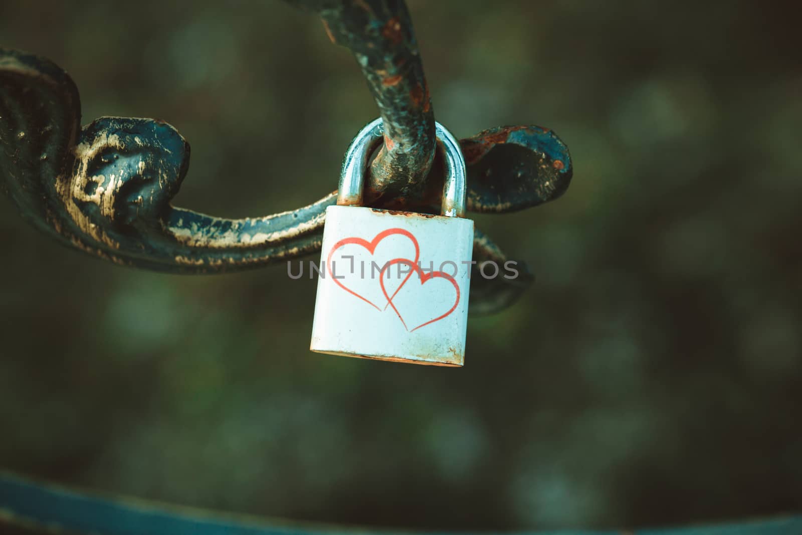 lock with two hearts hanging on the railing. by boys1983@mail.ru