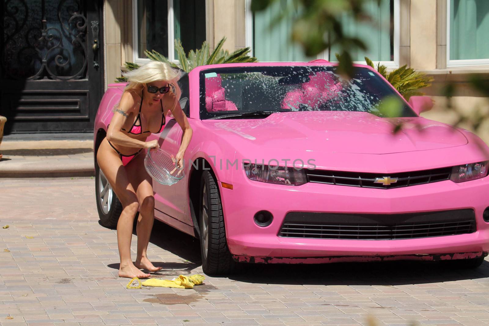 Frenchy Morgan the "Celebrity Big Brother" Star is spotted on a hot day wearing a tiny pink bikini while washing her pink car in Malibu, CA 05-22-17