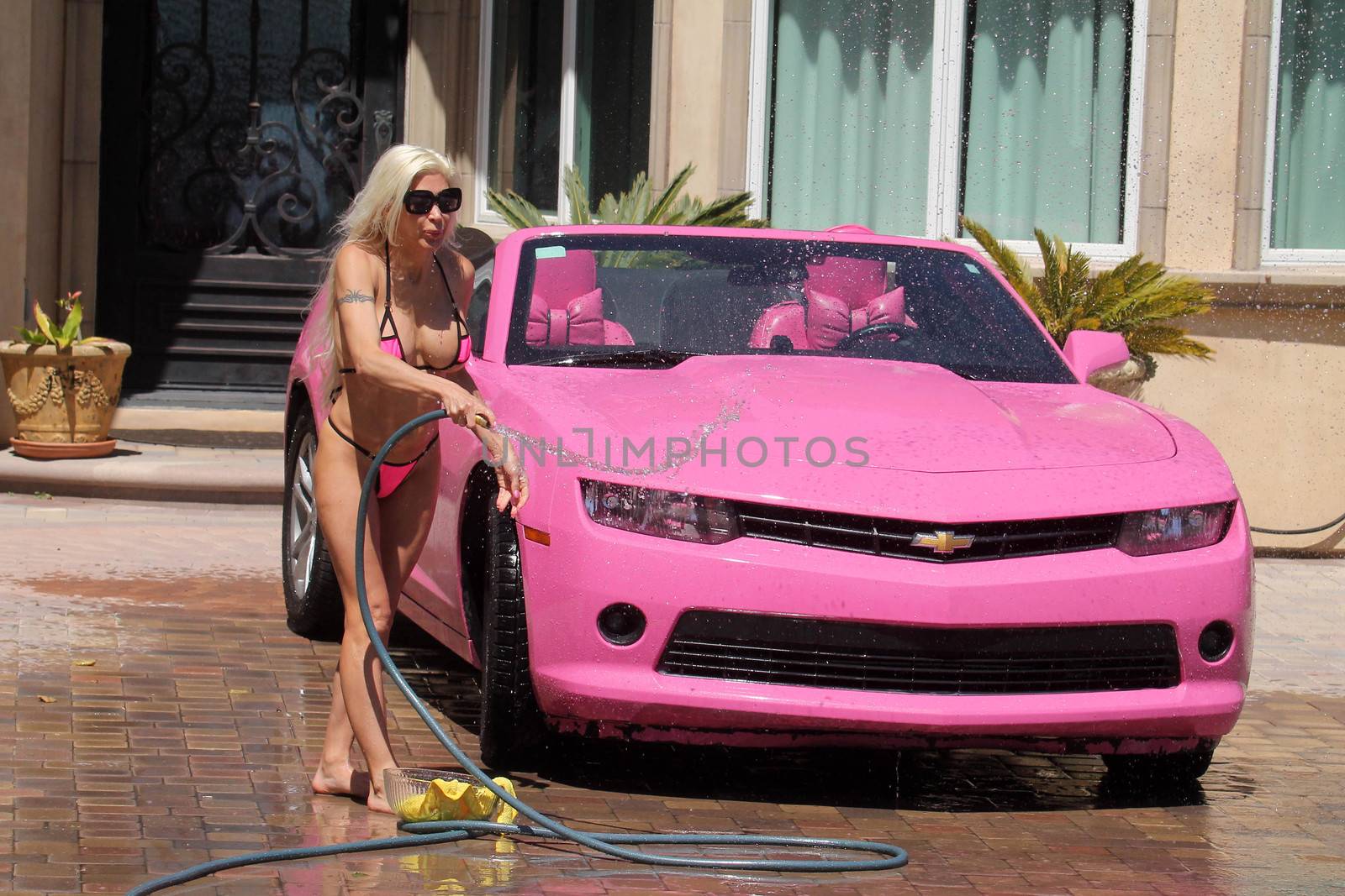 Frenchy Morgan the "Celebrity Big Brother" Star is spotted on a hot day wearing a tiny pink bikini while washing her pink car in Malibu, CA 05-22-17/ImageCollect by ImageCollect