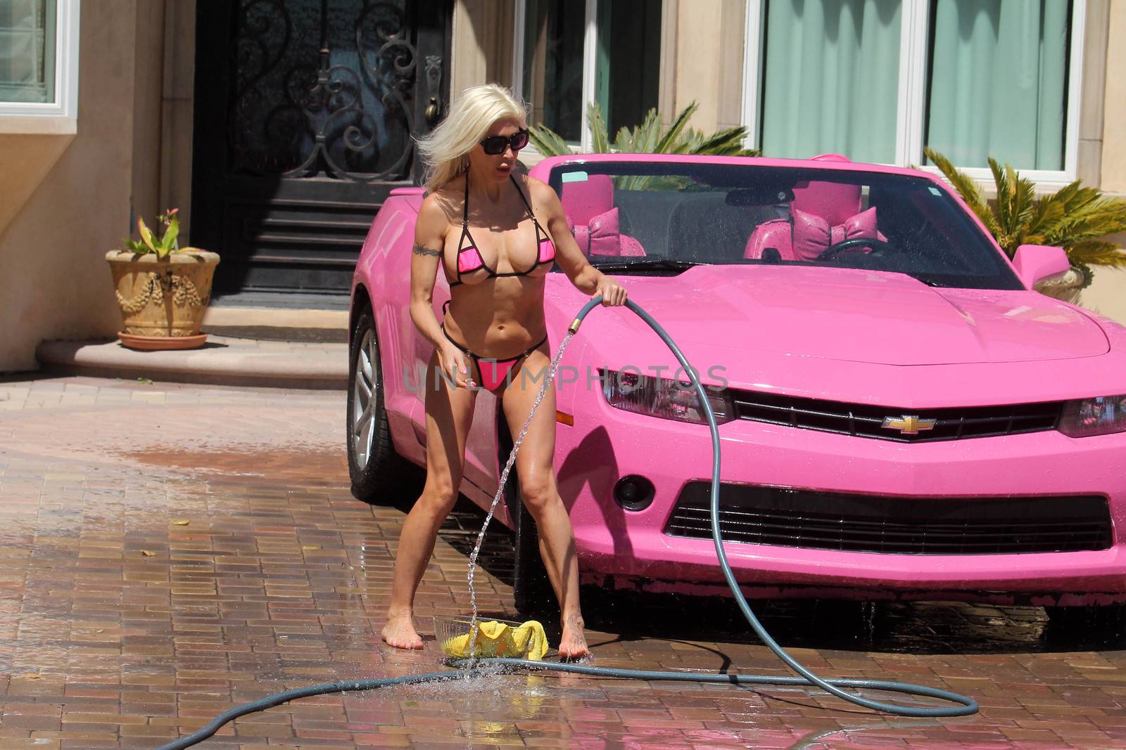 Frenchy Morgan the "Celebrity Big Brother" Star is spotted on a hot day wearing a tiny pink bikini while washing her pink car in Malibu, CA 05-22-17