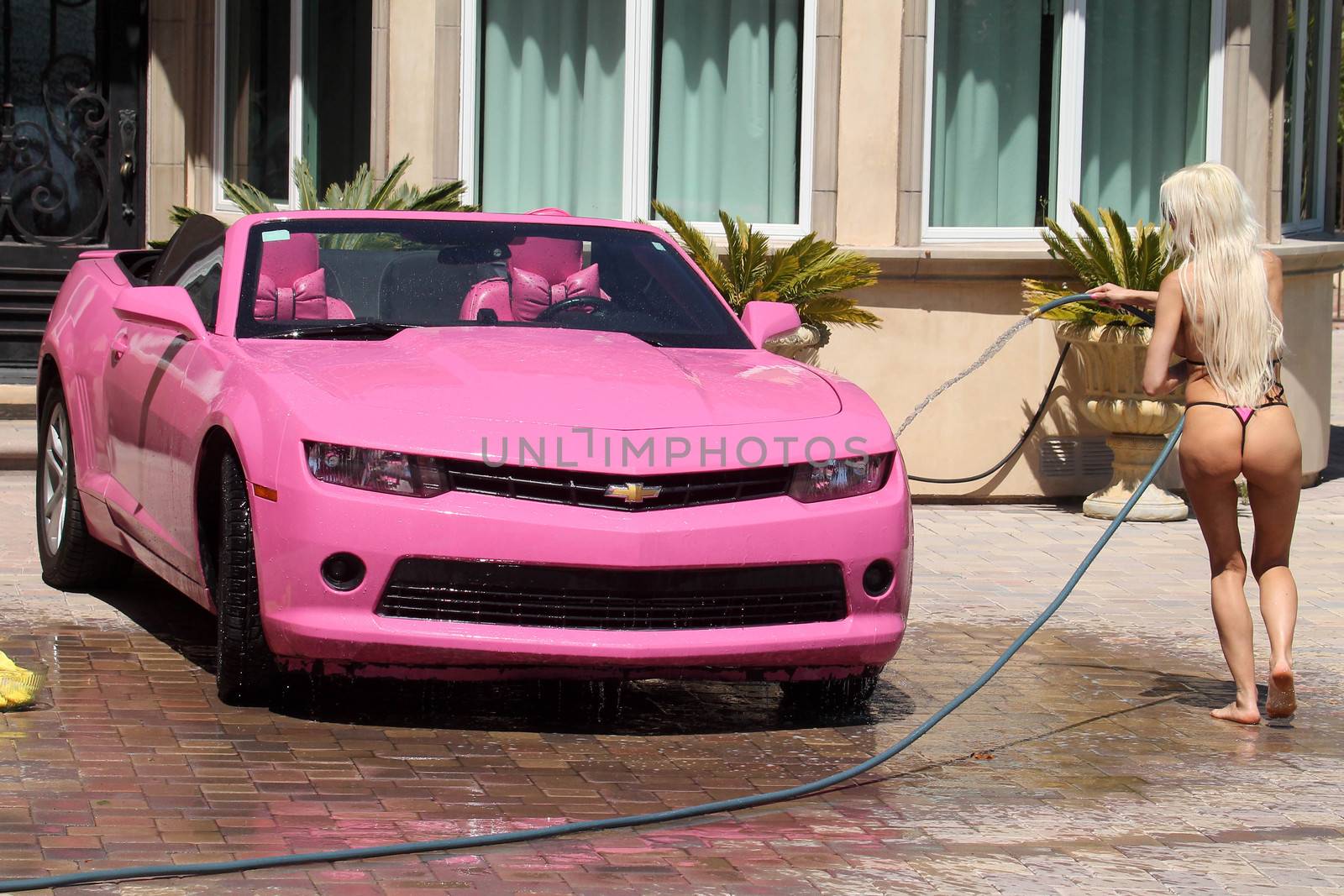 Frenchy Morgan the "Celebrity Big Brother" Star is spotted on a hot day wearing a tiny pink bikini while washing her pink car in Malibu, CA 05-22-17