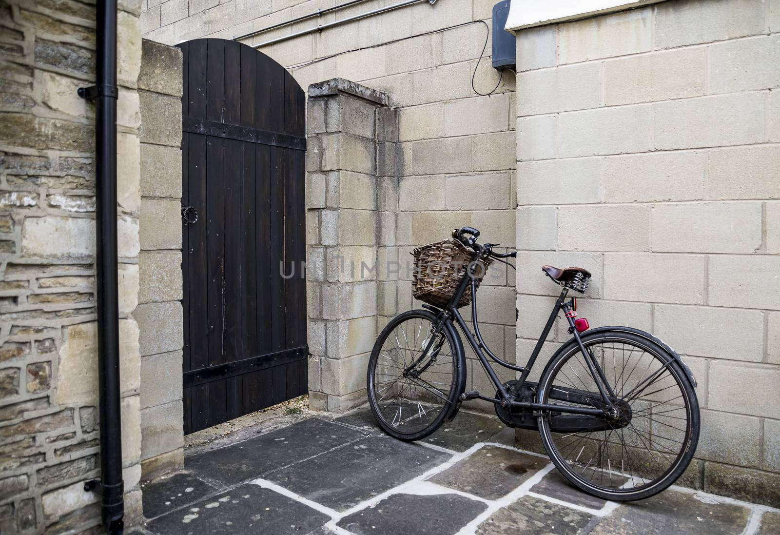 Retro black bycicle parked near wall in small British village