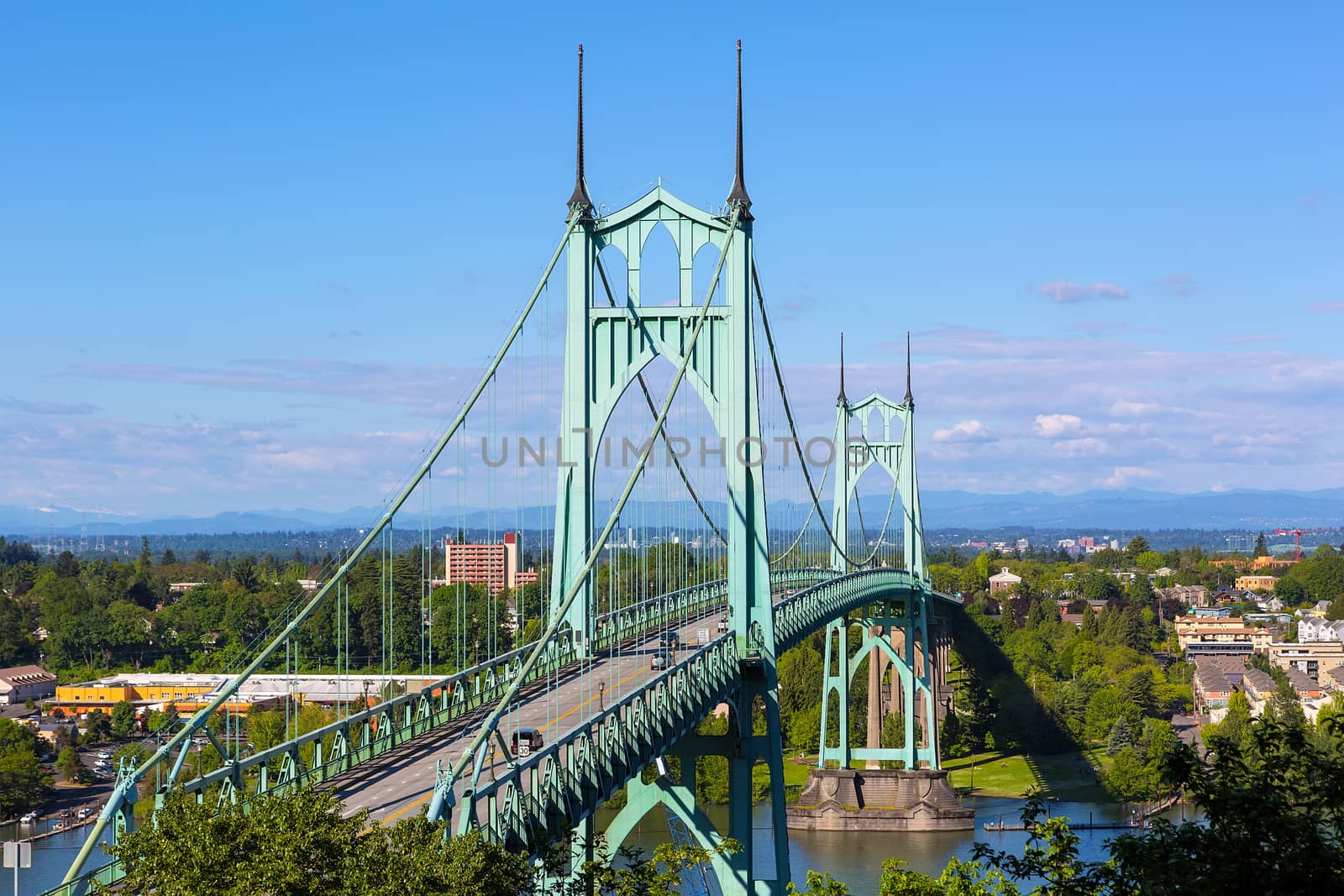St Johns Bridge over Willamette River and Cathedral Park in Portland Oregon on a blue sky sunny day