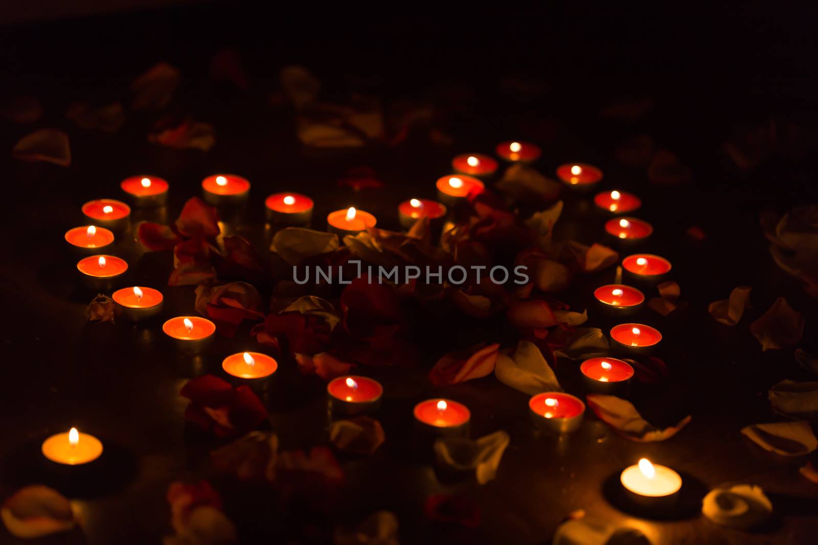 rose petals. romantic evening. candles. heart from candles and rose petals