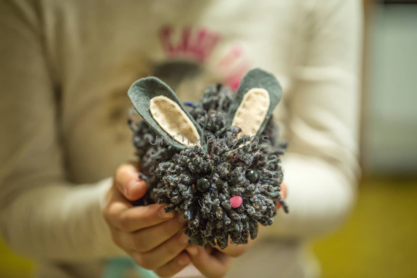 the girl in the hands holding knitted hedgehog