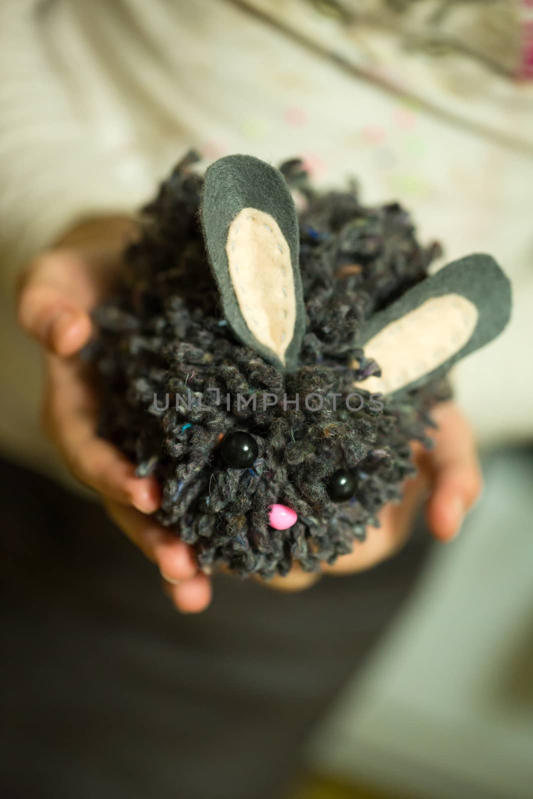 the girl in the hands holding knitted hedgehog