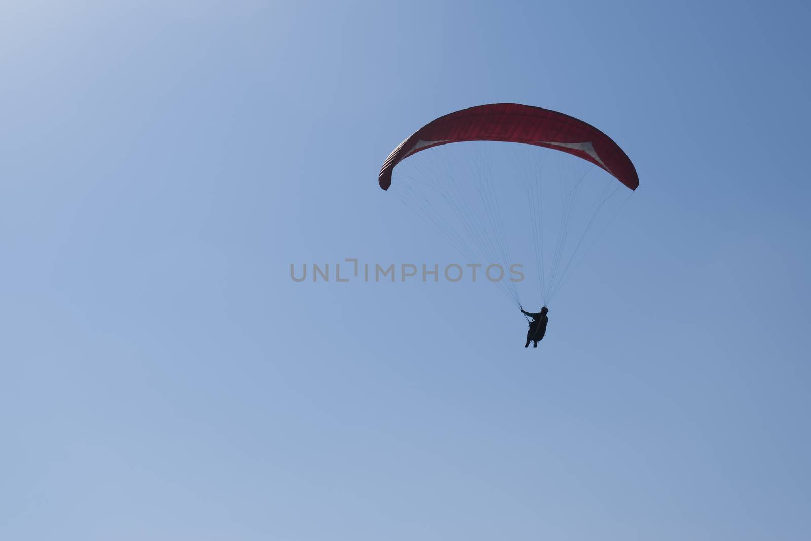 Colorful hang glider in sky over blue sea 