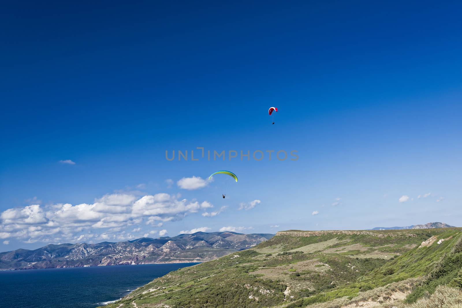 Colorful hang glider in sky over blue sea 