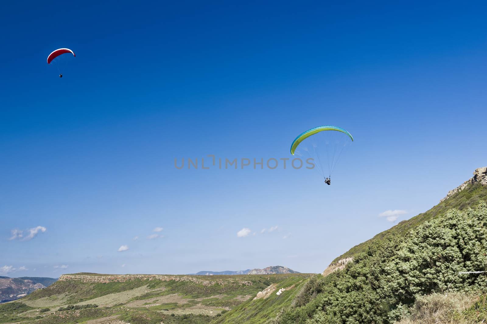 Colorful hang glider in sky over blue sea 