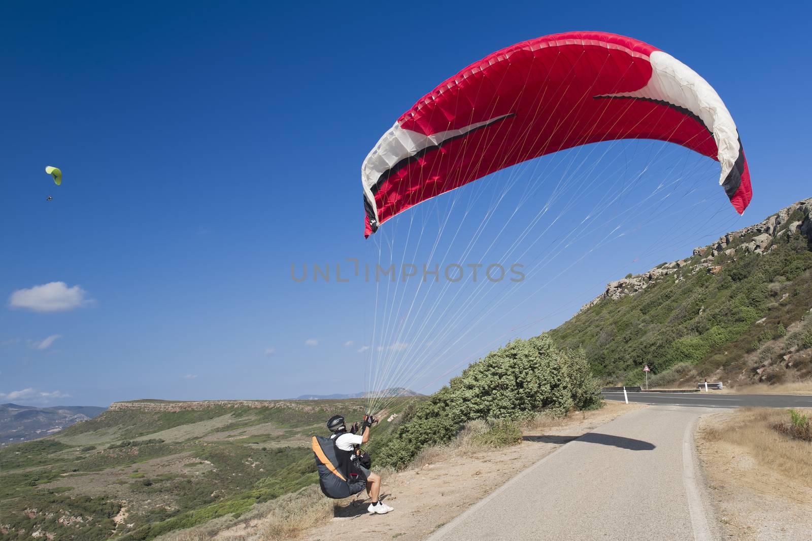 Colorful hang glider in sky over blue sea 